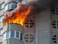 Flammen schlagen aus einem Balkon eines Wohnhauses. Ein Wohnungsbrand kann schnell passieren, eine gute wohnungsbrand versicherung ist wichtig.