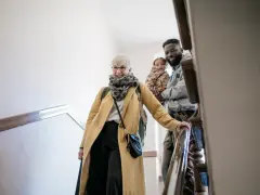 Glückliche Familie auf Treppe, die sich auf den Weg macht. Mit Ehe-Rechtsschutz ohne Wartezeit sind sie für alles gerüstet.