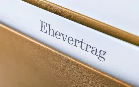 Ein Ehevertrag in einem braunen Ordner. Die Frage, ob man einen Ehevertrag aufheben ohne Notar kann, beschäftigt viele.