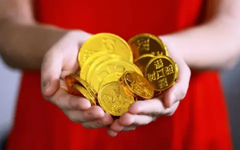 Hände halten einen Haufen glänzender Goldmünzen. Das ist ein schöner Gedanke, wann Urlaubsgeld!