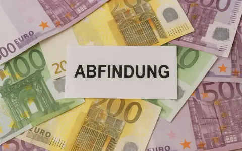 Euro-Scheine liegen unter einem Zettel mit dem Wort "Abfindung". Vielleicht eine finanzielle Unterstützung für jemanden, der mit 64 Jahren in den Ruhestand geht.