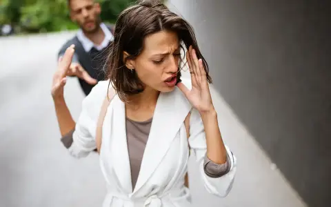 Frau wehrt Mann ab, der sie festhalten will. Ein trauriger Moment, der auf eine bevorstehende Aufhebung der Ehe hindeutet.