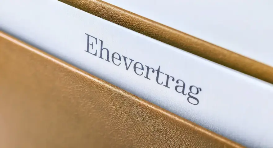 Ein Ehevertrag in einem braunen Ordner. Die Frage, ob man einen Ehevertrag aufheben ohne Notar kann, beschäftigt viele.
