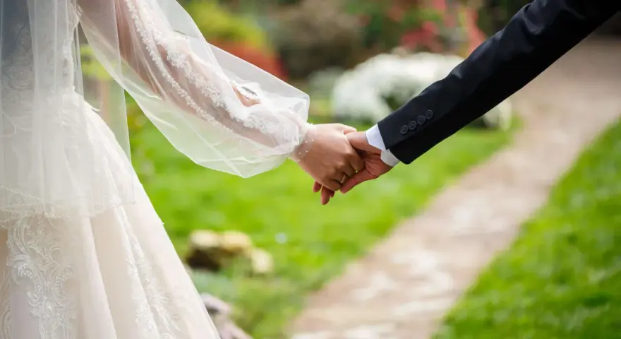 Brautpaar hält Händchen, ein Zeichen für ihren Sonderurlaub zur Hochzeit.