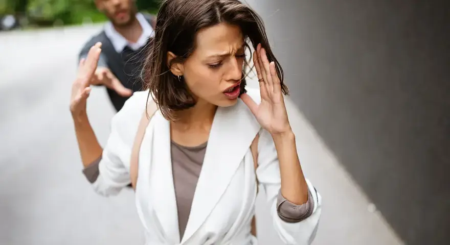 Frau wehrt Mann ab, der sie festhalten will. Ein trauriger Moment, der auf eine bevorstehende Aufhebung der Ehe hindeutet.