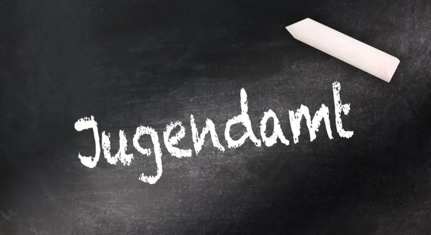 Kreide auf Tafel: "Jugendamt". Eine Empfehlung des Jugendamtes zum Umgangsrecht kann hier notiert werden.