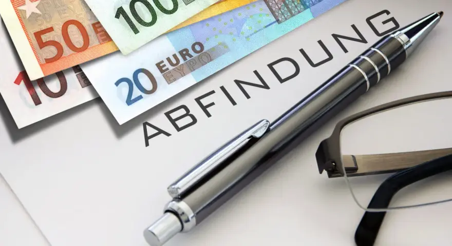 Euro-Scheine liegen neben einem Dokument mit dem Wort "Abfindung". Ein Stift und eine Brille deuten auf eine bevorstehende Entscheidung hin, vielleicht eine Abfindung nach 4 Jahren.