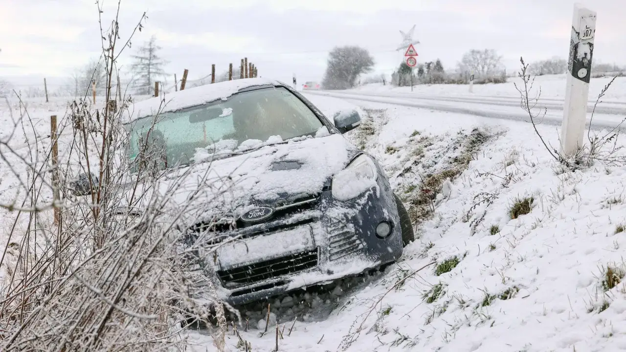 Schneebedeckter Ford im Graben, ein Beispiel für das Wegerisiko für Arbeitnehmer bei winterlichen Straßenverhältnissen.